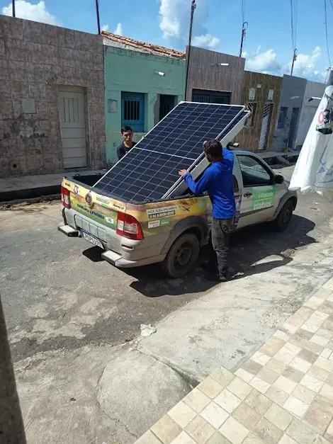 Técnico da J Solar descarregando uma placa solar na rua do cliente