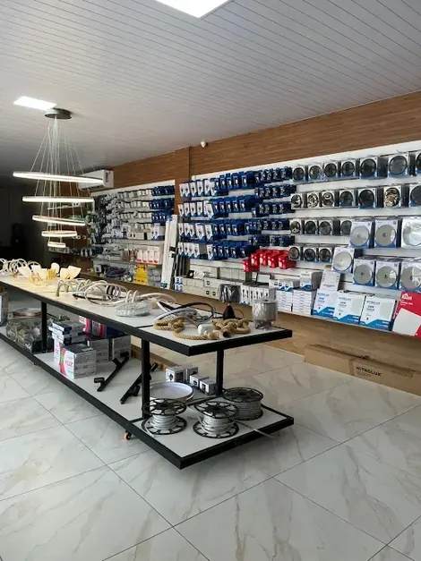 Prateleiras com iluminação e material elétrico na loja da J Solar